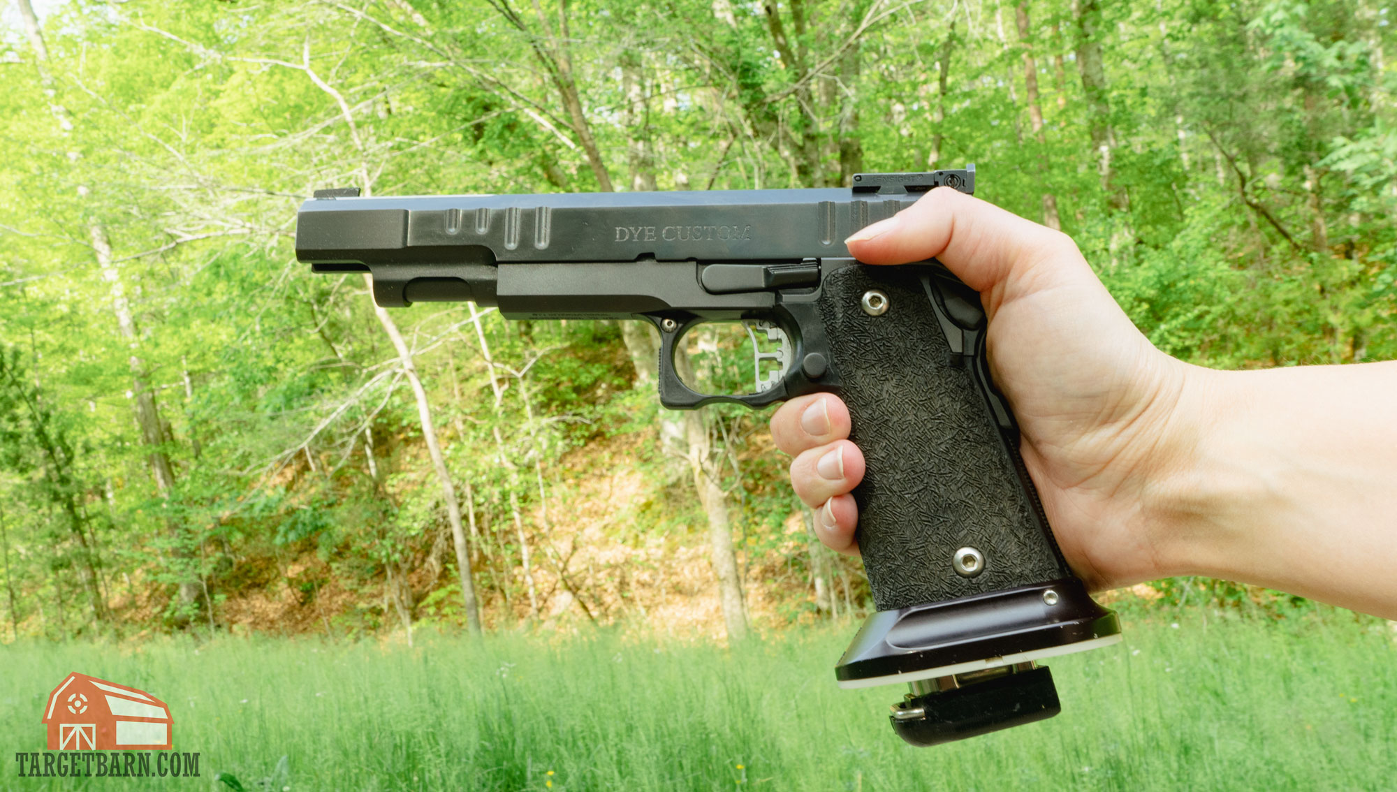 a dye custom 2011 being held in one hand at the range