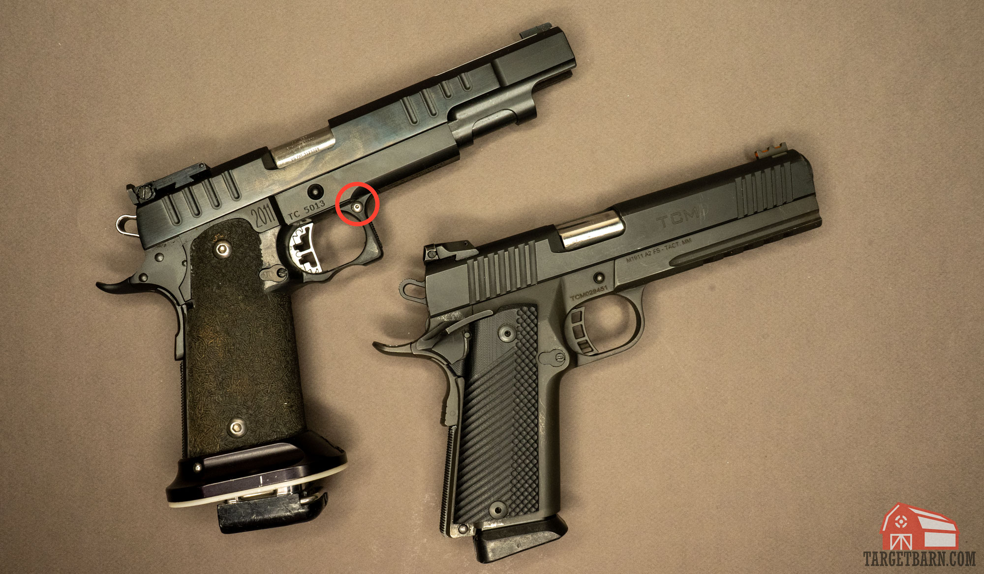 a 2011 and 1911 next to each other, with the screw on the trigger guard of the 2011 circled to show the difference
