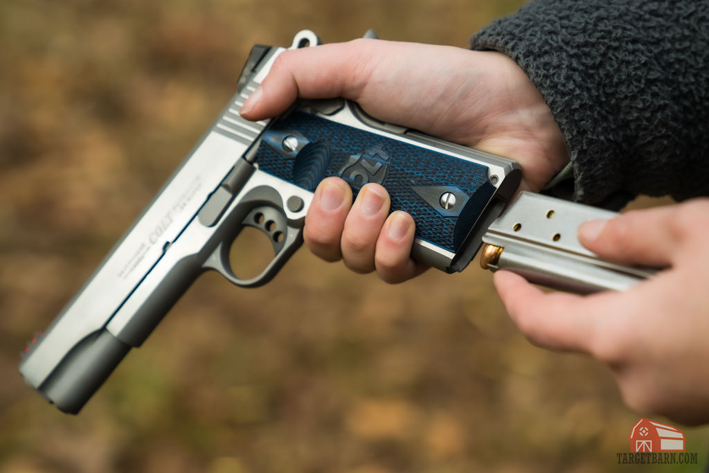 a modern colt .38 super 1911 competition gun being loaded
