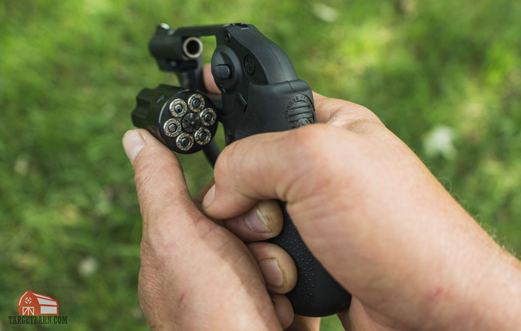 hands holding a 32 revolver with an open cylinder