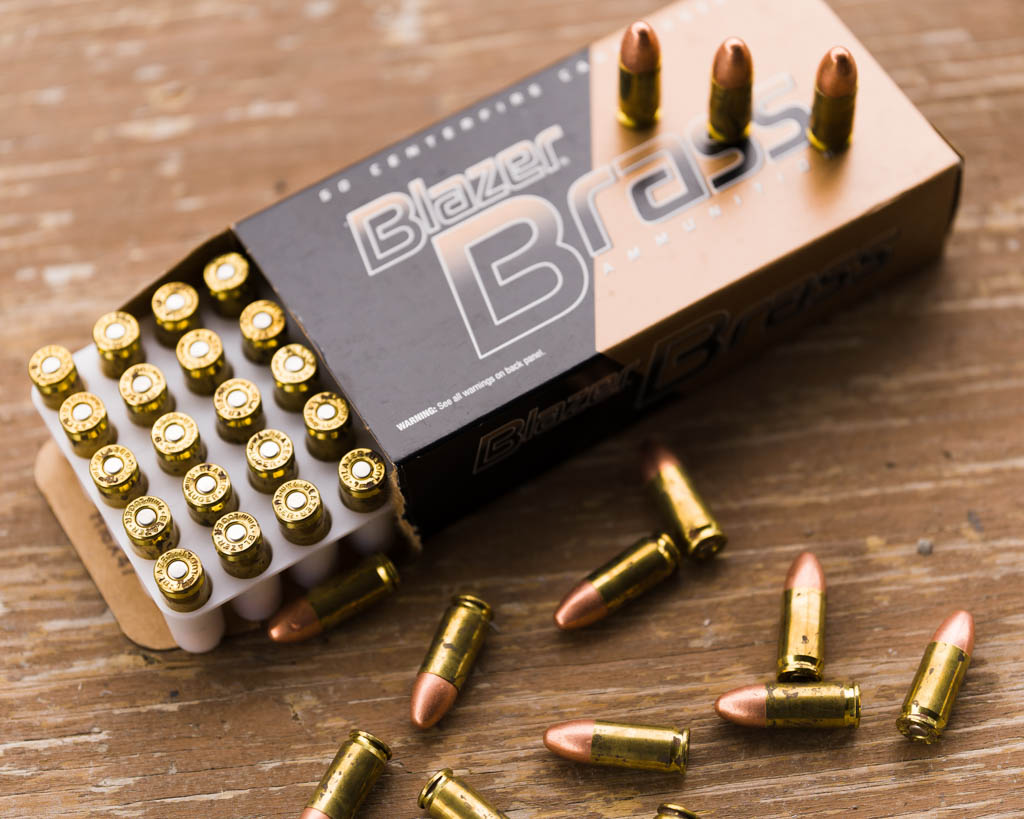 a box of Blazer Brass 9mm FMJ opened with rounds laying on the table