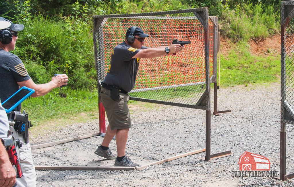 a uspsa competitor shooting a stage in carry optics division