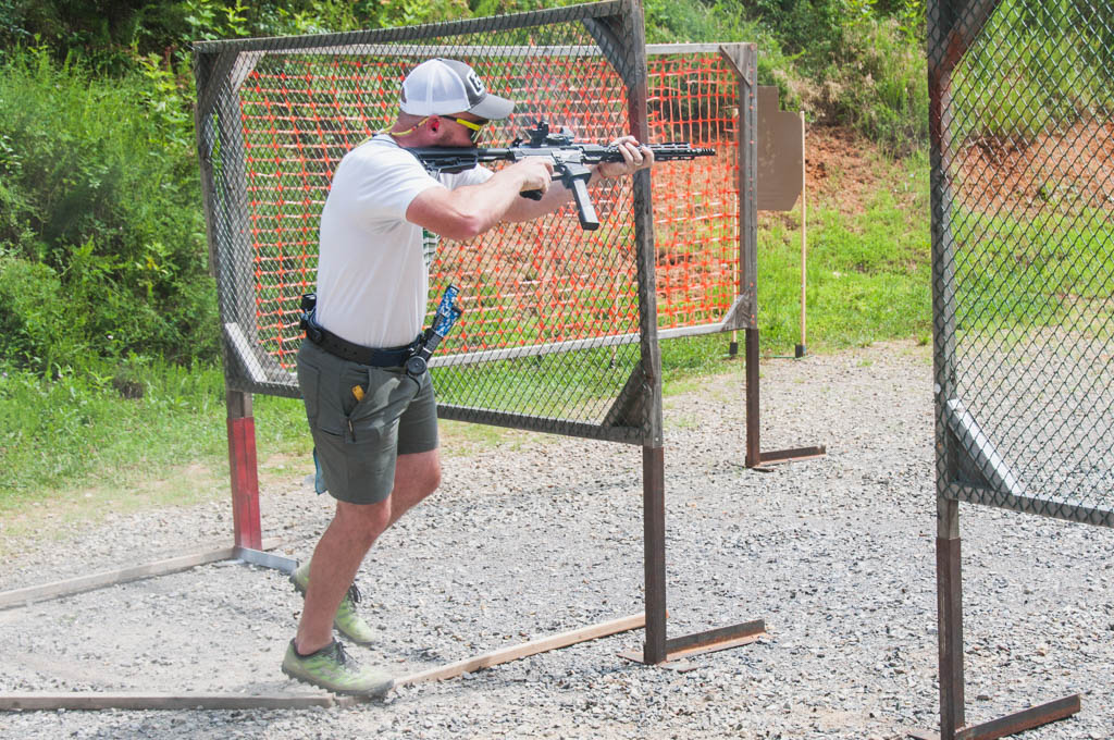a PCC shooter at a USPSA match using a second off-set red dot optic for a sharp corner