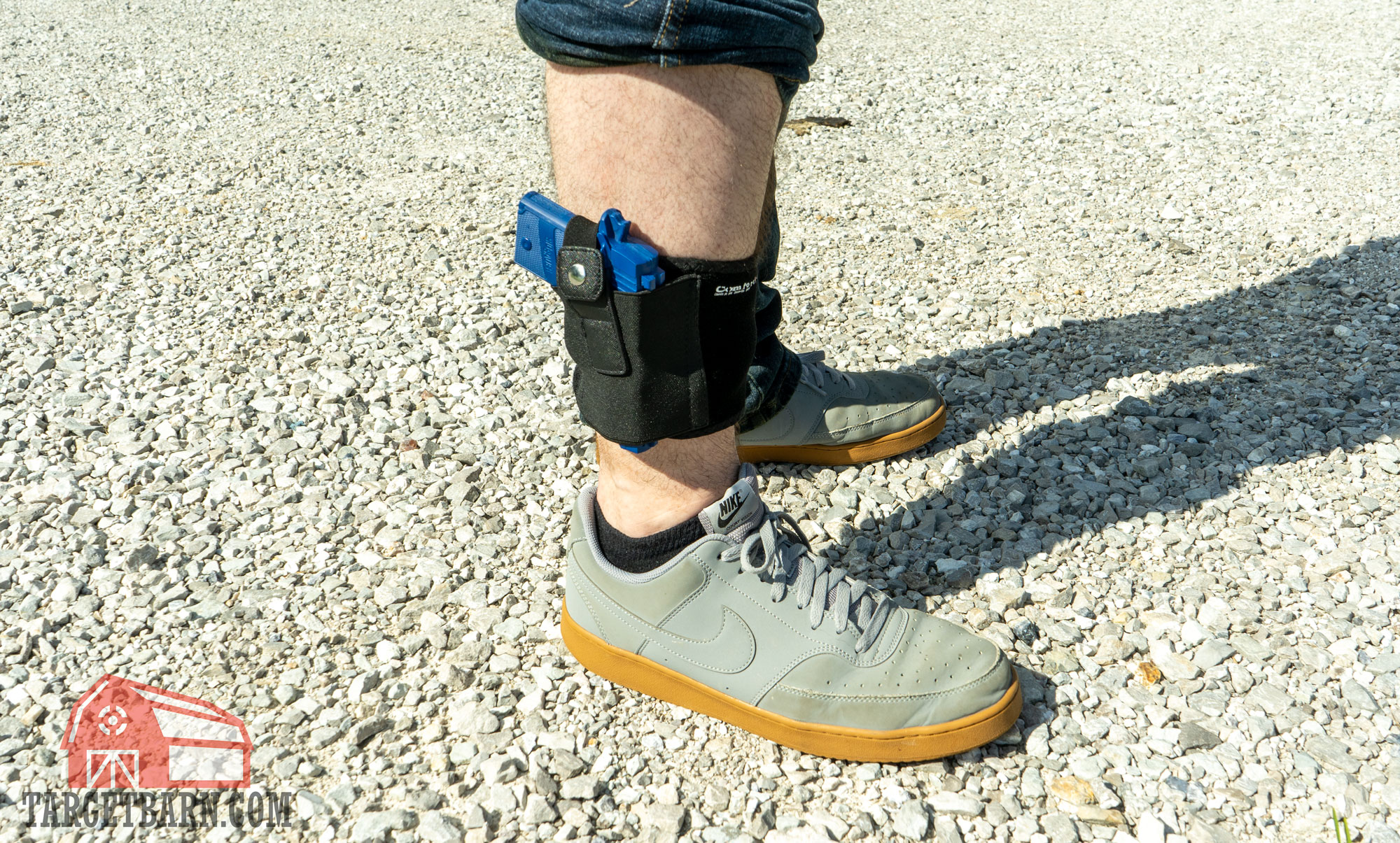 a man carrying a blue gun in an ankle holster 