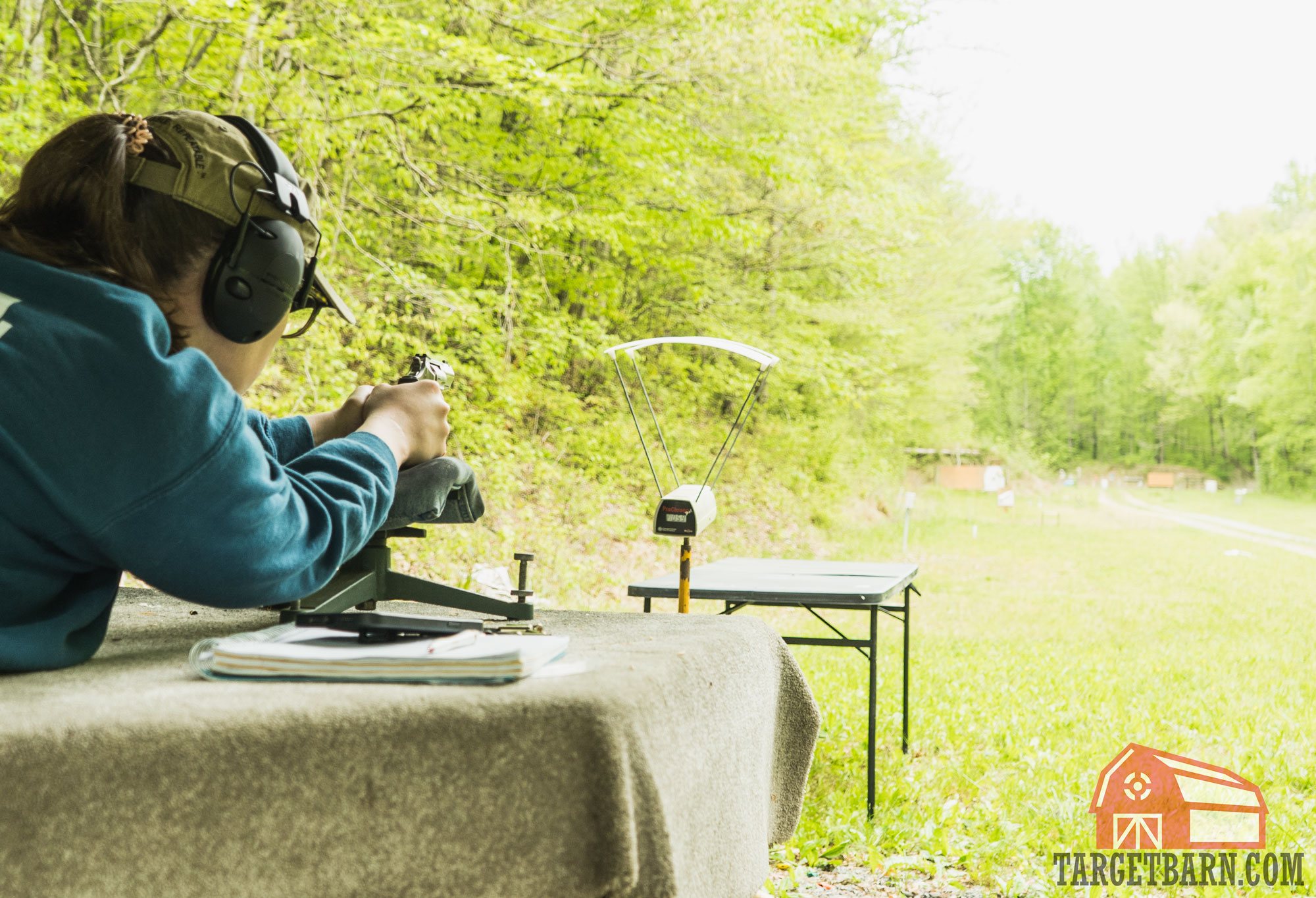 the author shooting rounds through a chronograph on a bench at the range