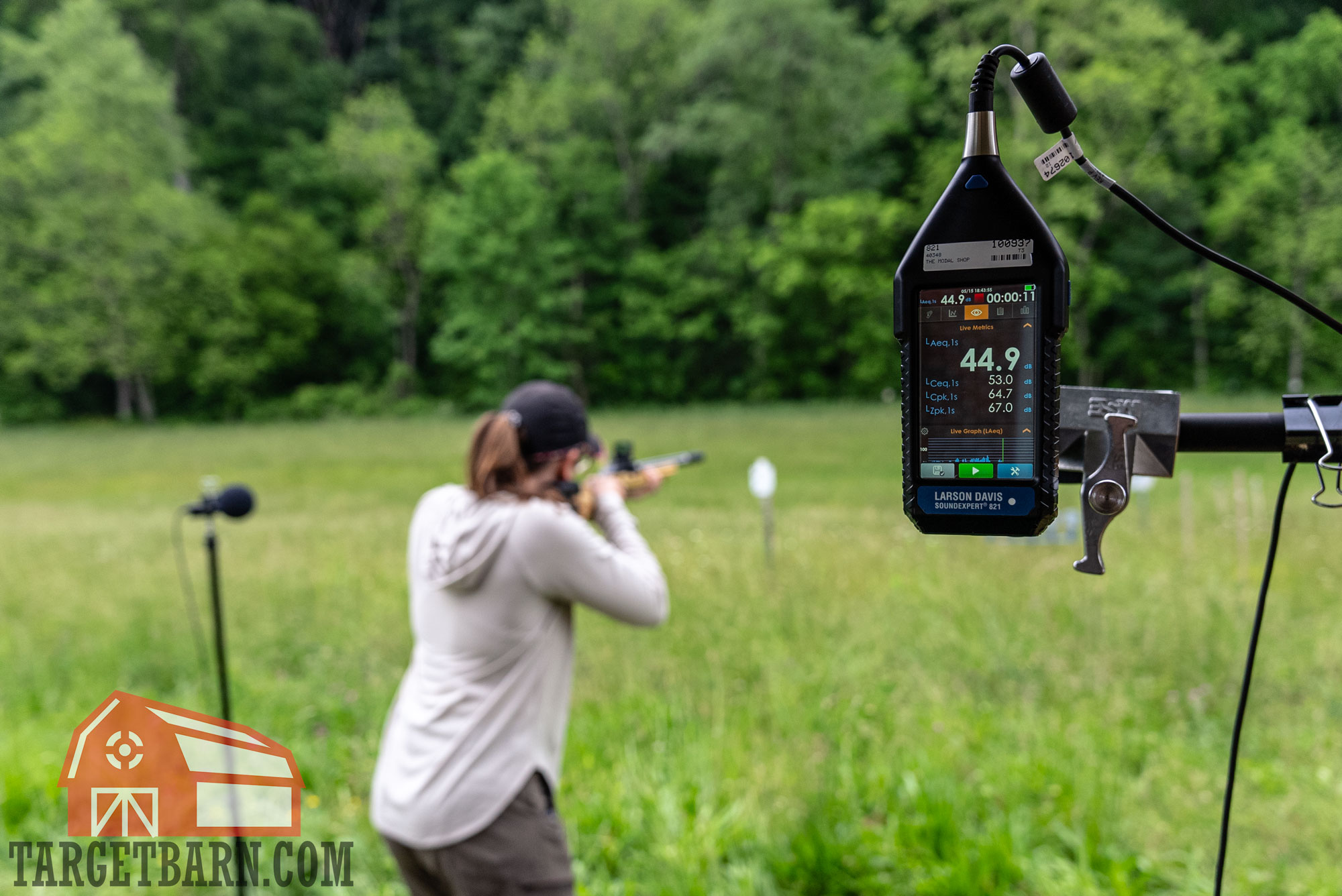 a woman decibel testing a suppressed rifle