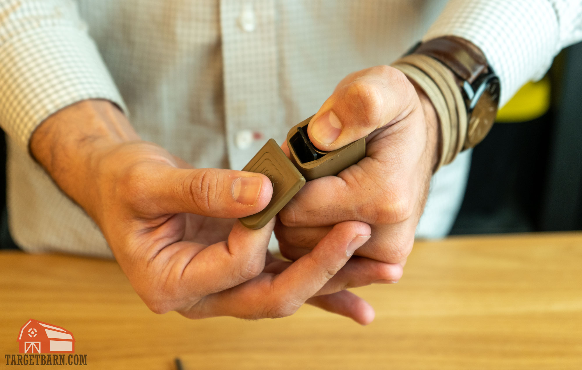 sliding off the floor plate while a thumb holds down the magazine spring
