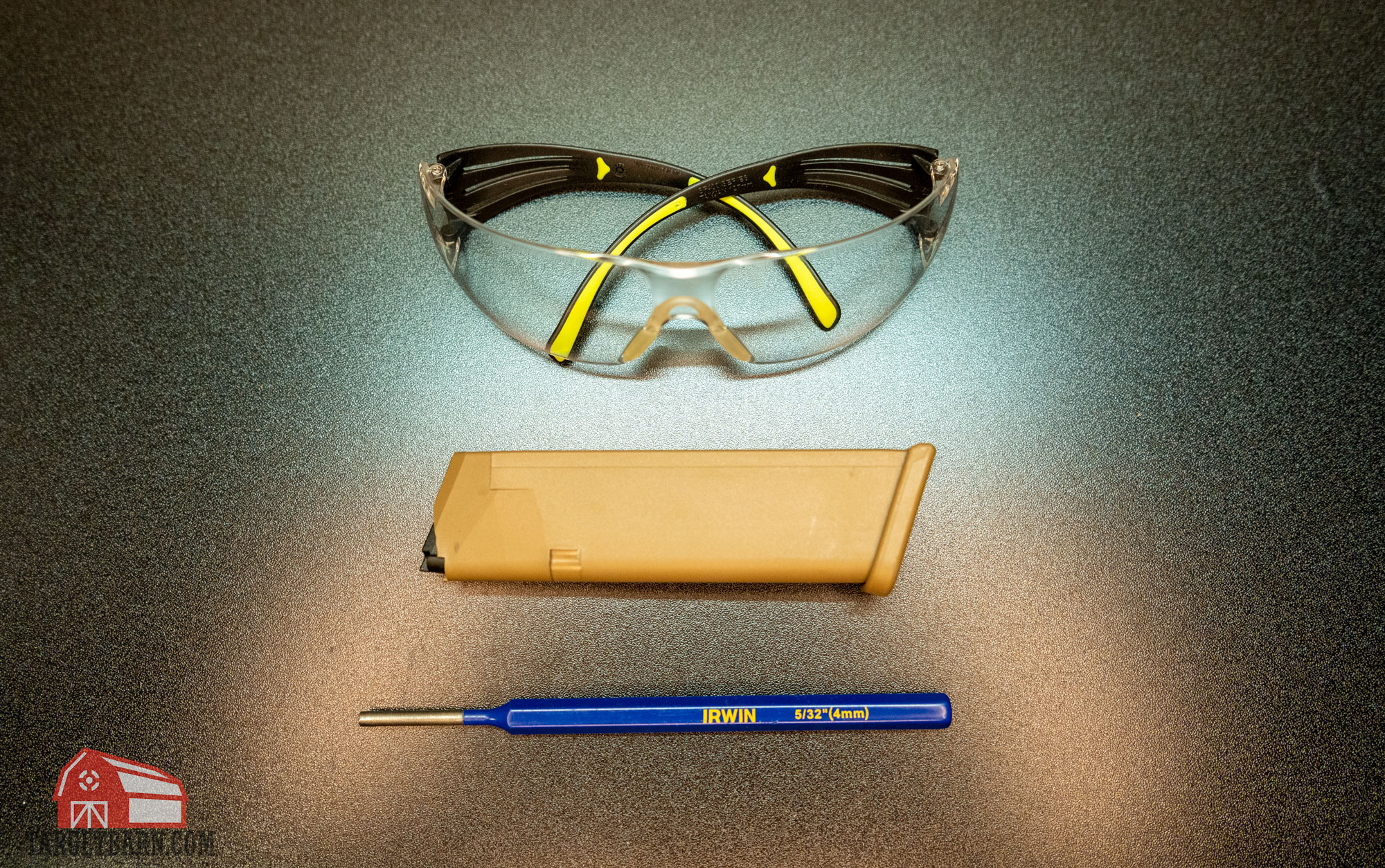 safety glasses, a glock magazine, and a punch