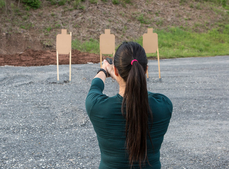 Demonstrating upper body pistol shooting position for recoil management