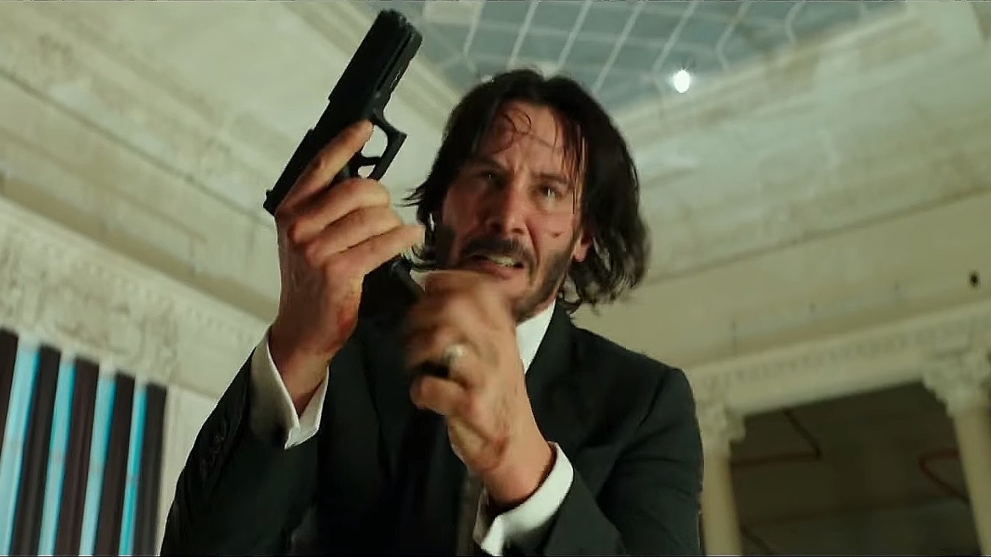 a still image from the movie john wick: chapter 2 showing john wick performing a magazine reload with proper trigger discipline