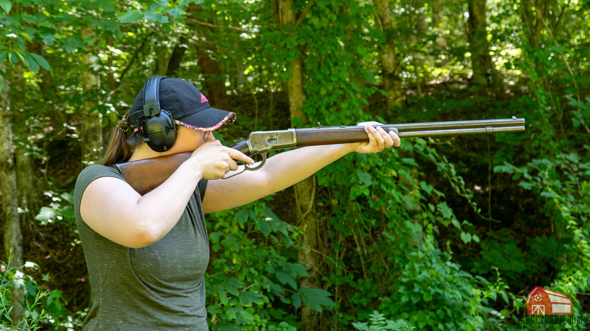 a woman shooting a lever-action rifle at the range