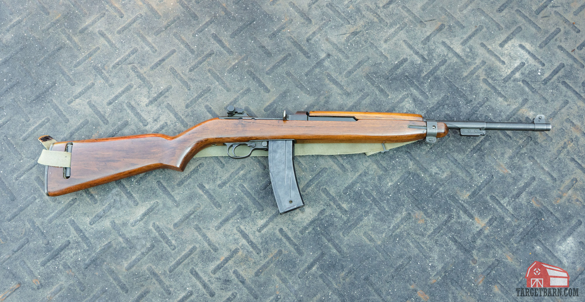 an m1 carbine laying on the ground with a 30 round magazine inserted