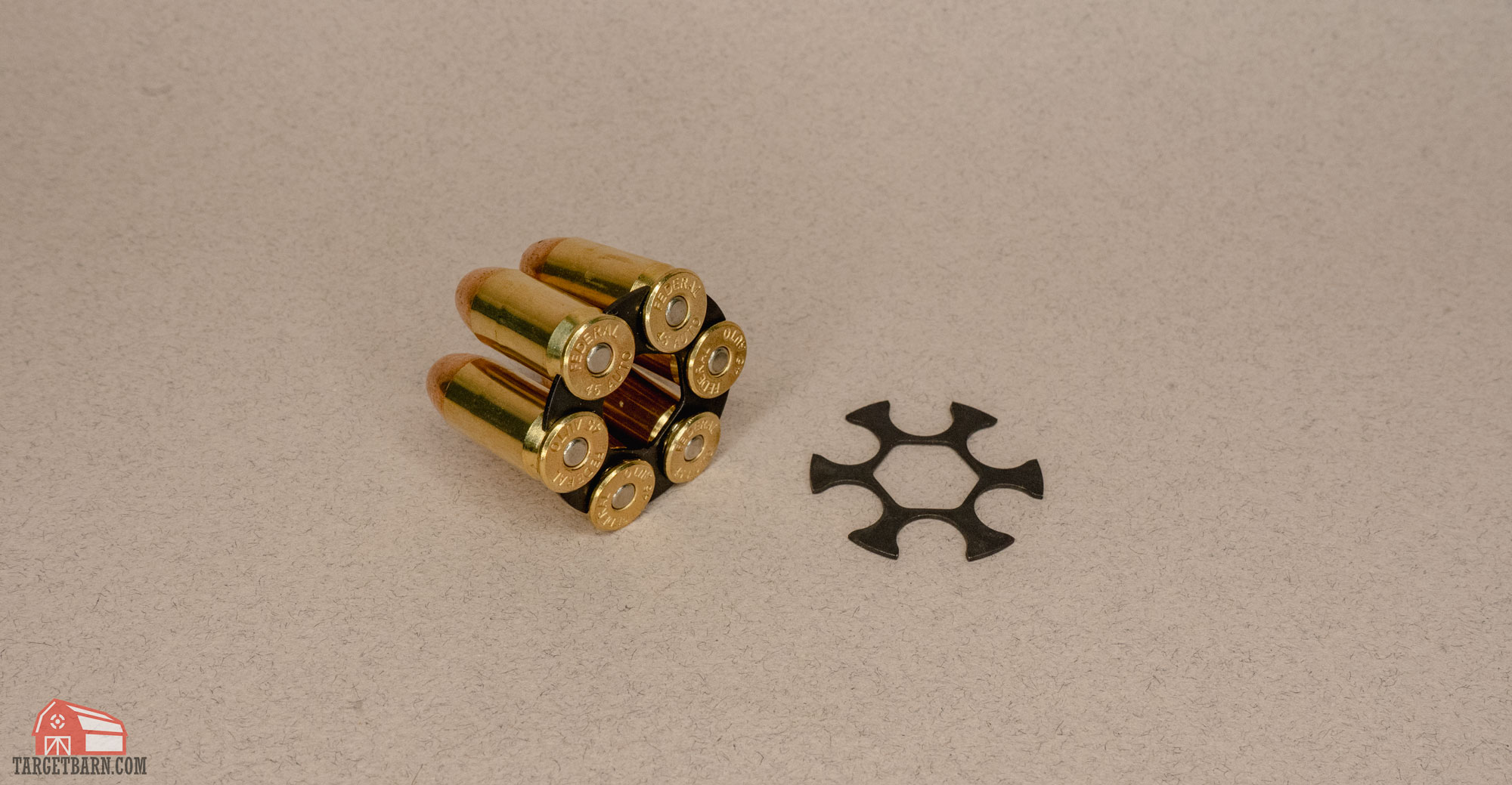 a moon clip loaded with .45 acp rounds next to an empty moon clip