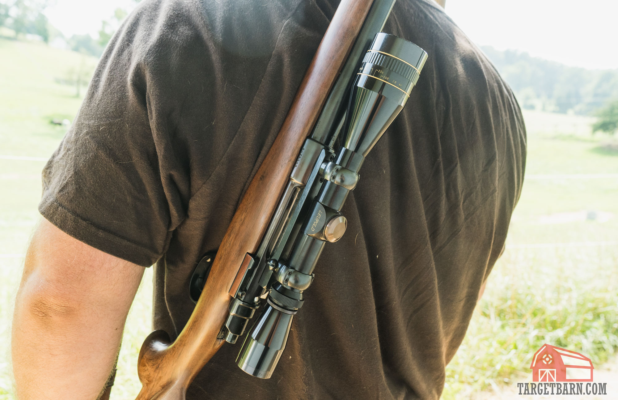 an older leupold scope on an old hunting rifle hanging over a man's shoulder