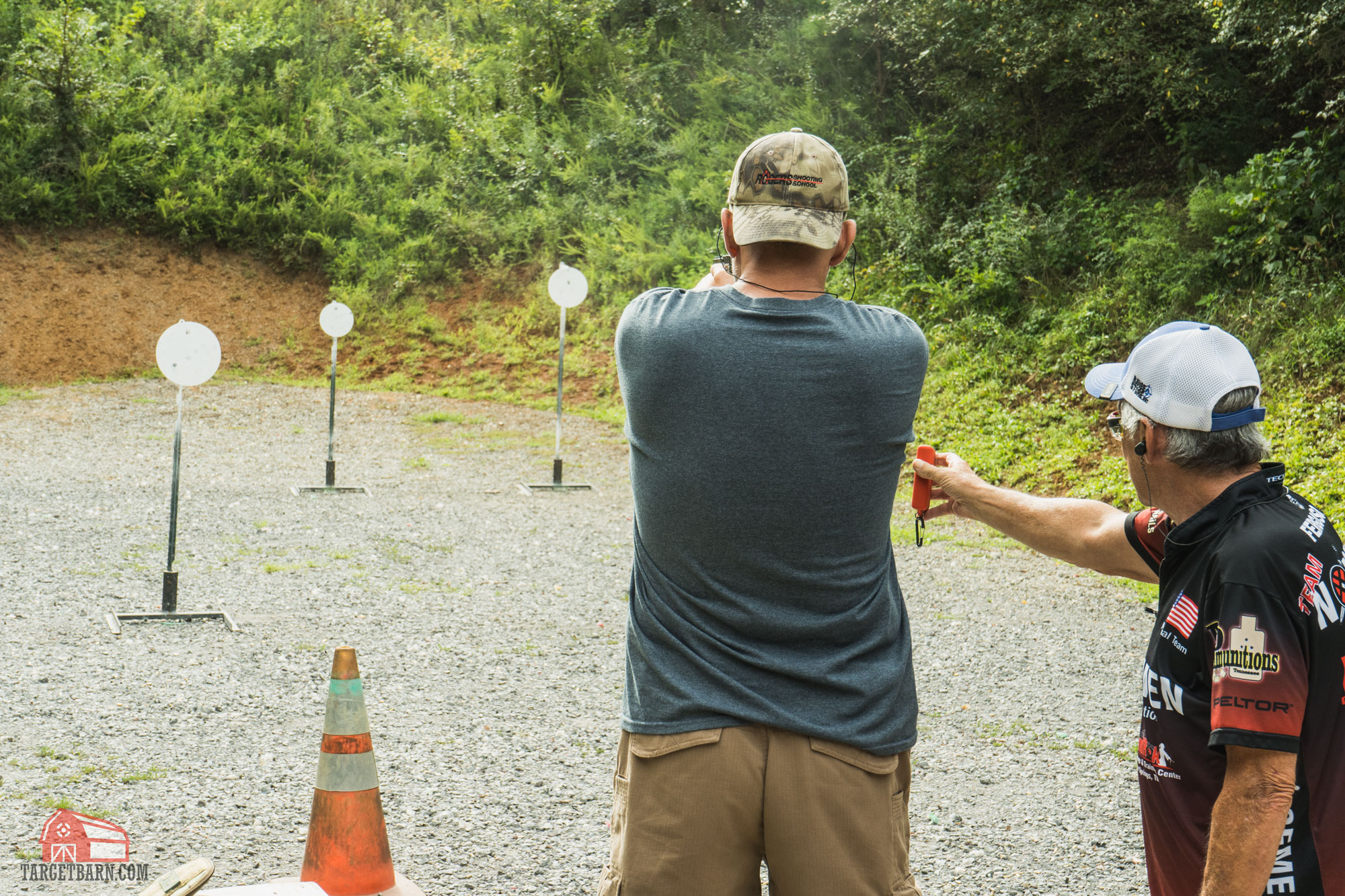 a range officer (RO) running a shooter through a steel challenge stange