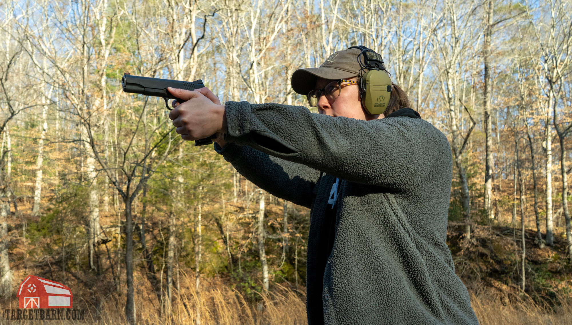 a woman shooting a 1911 at the range