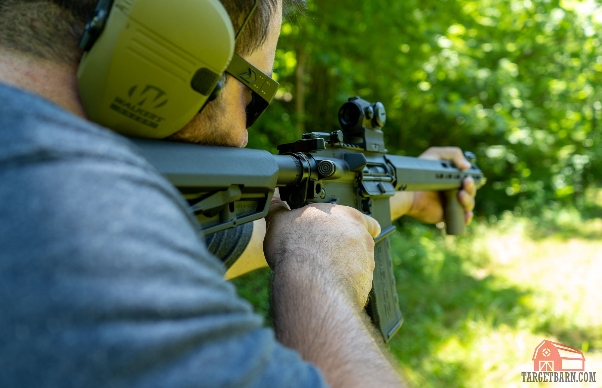 a man shooting an ar-15 at the range with a forward assist