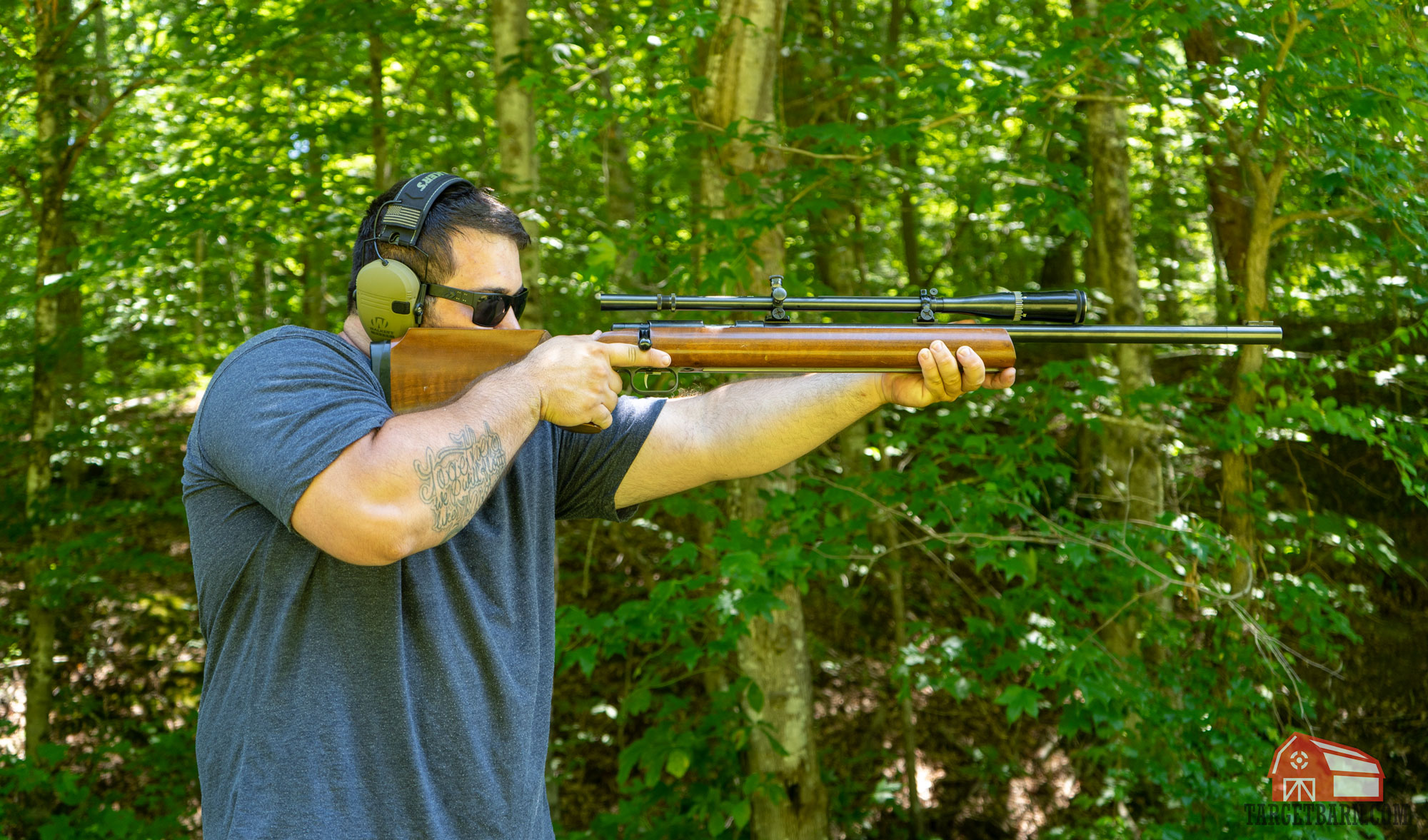 a man shooting a single shot bolt action anschutz rifle