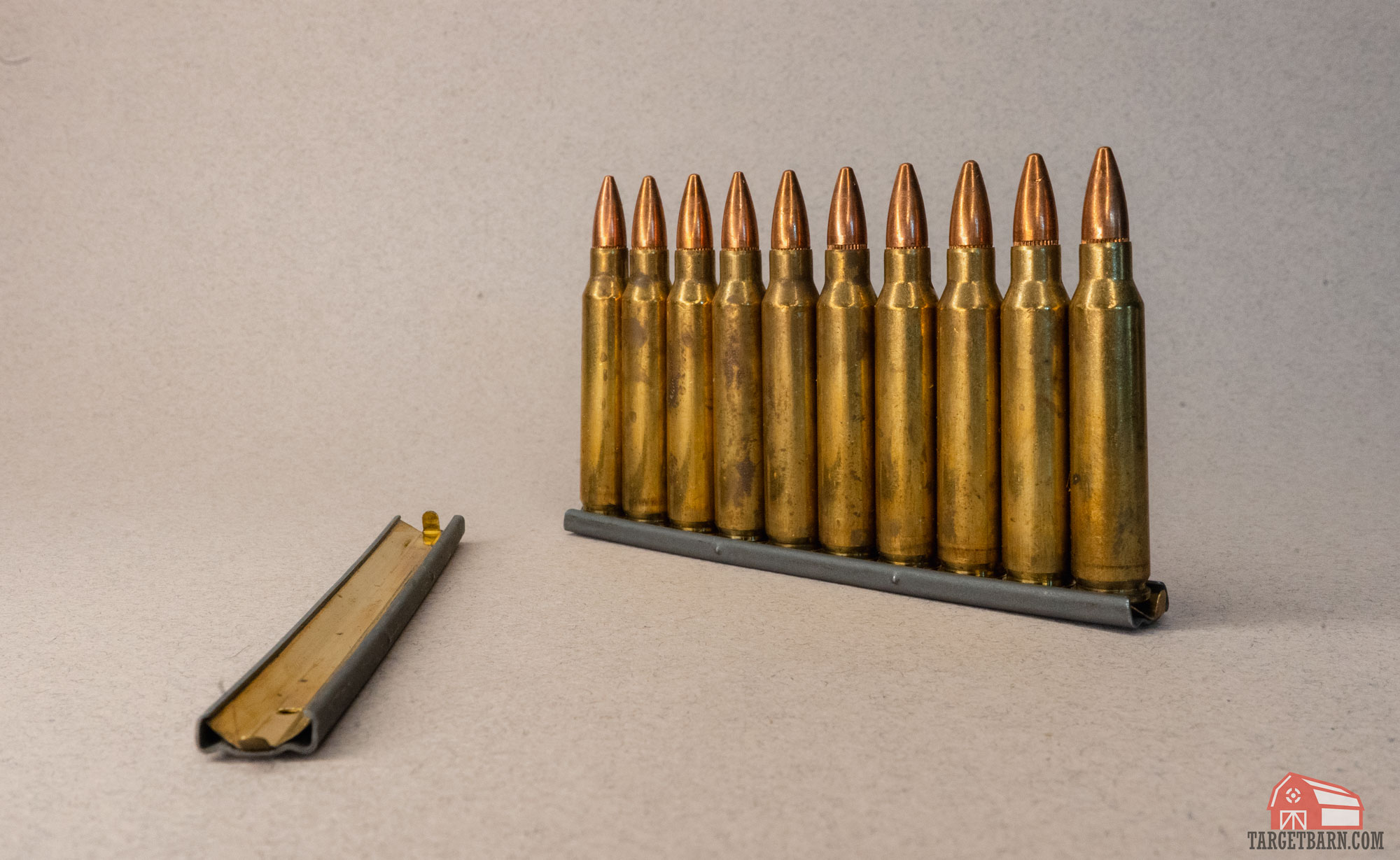 an empty stripper clip next to a stripper clip loaded with .223 rounds