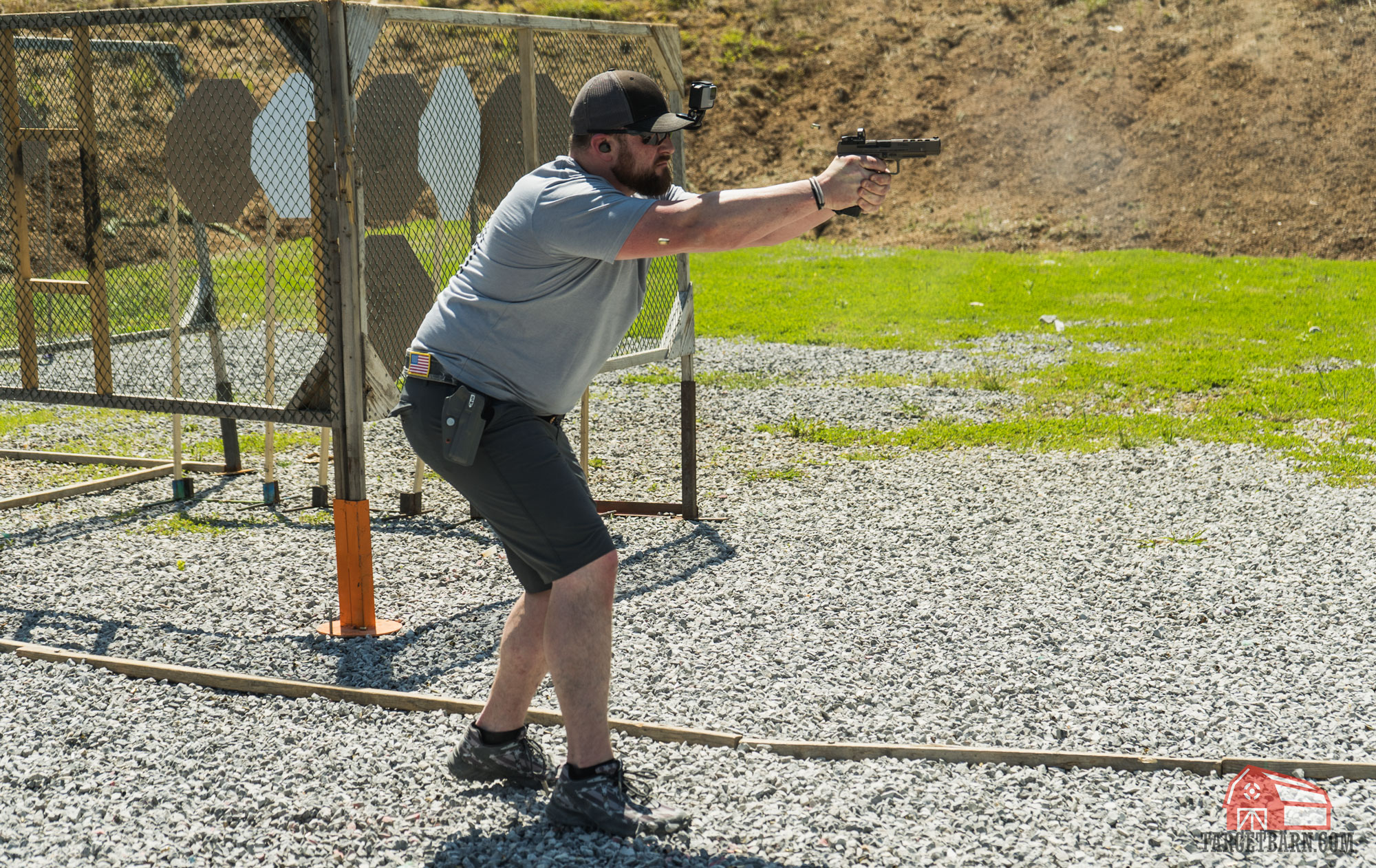 a competitor shooting his pistol during a stage at a uspsa match